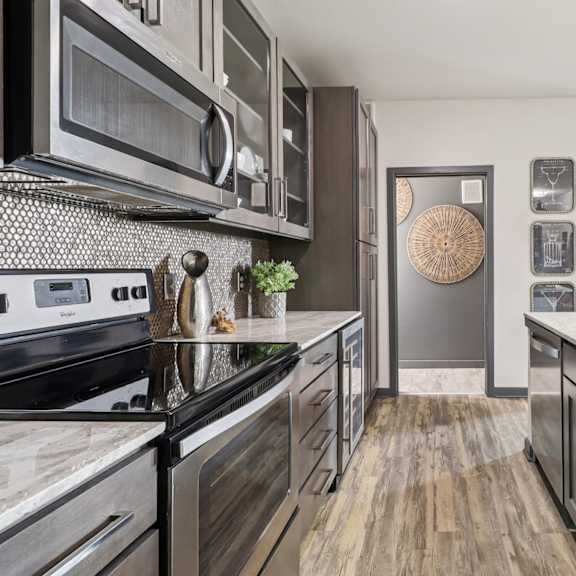 a modern kitchen with dark wood cabinets and stainless steel appliances.