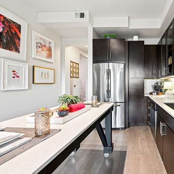 a modern kitchen with dark brown cabinets and a white countertop.