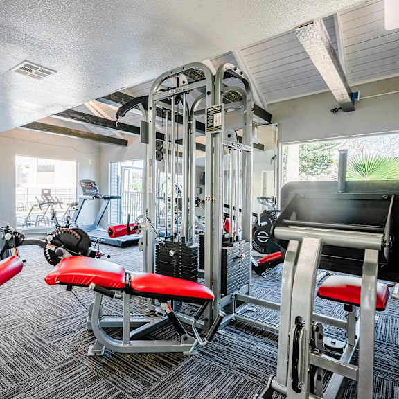a gym with a variety of equipment including a leg press machine.