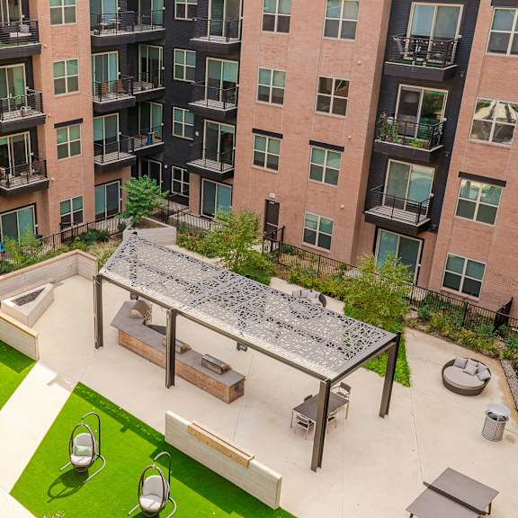 a patio with a table and chairs is surrounded by apartment buildings.