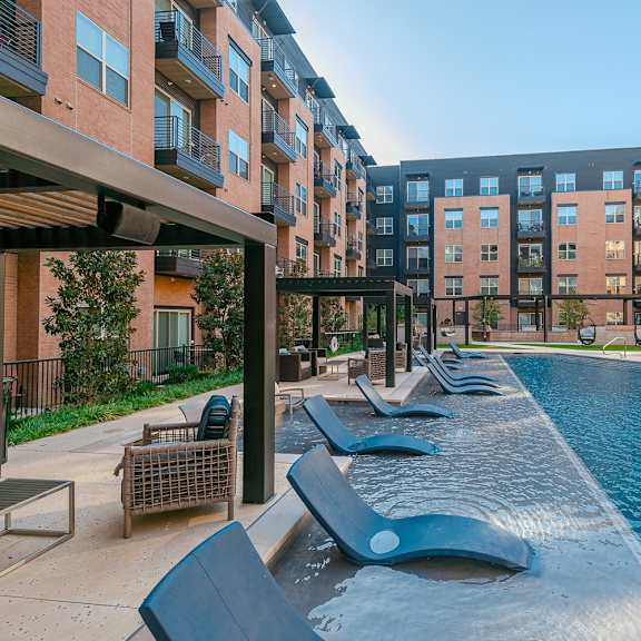 a pool area with a water slide and lounge chairs.