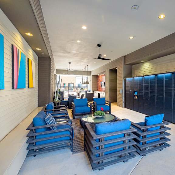 a modern outdoor seating area with blue cushioned chairs and tables.