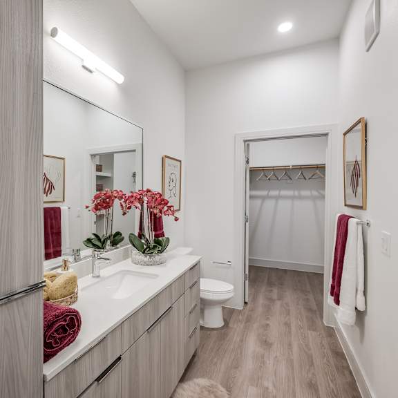 a bathroom with white walls and wood flooring