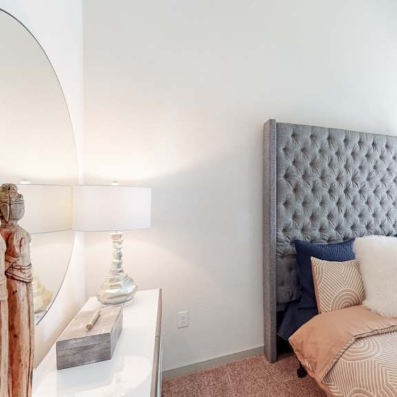 a bedroom with a large bed and a mirror on the wall.