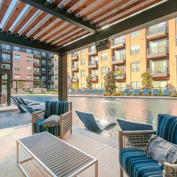 a patio with a table and chairs overlooking a body of water.