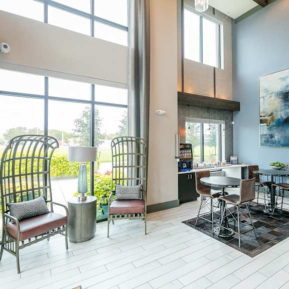 a room with a table and chairs in front of a large window.