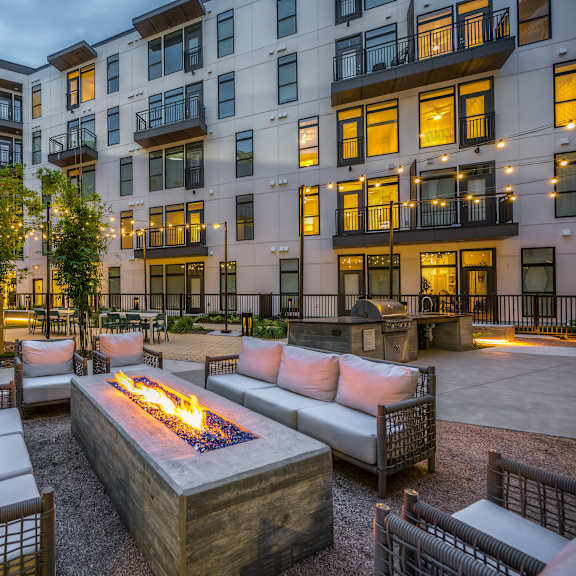an outdoor patio with couches and a fire pit