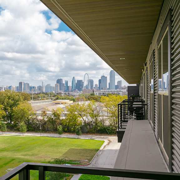 a city skyline is visible in the distance from a balcony.