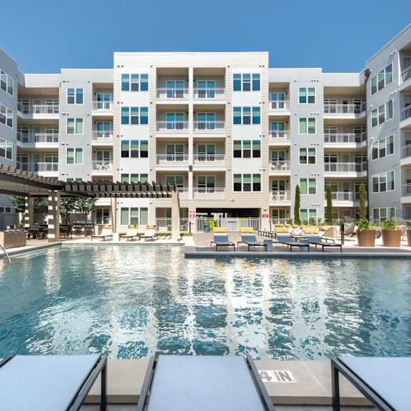 a large swimming pool is surrounded by apartment buildings.