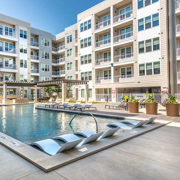a large swimming pool in front of apartment buildings.