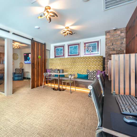 a room with a desk, chairs, and a computer.