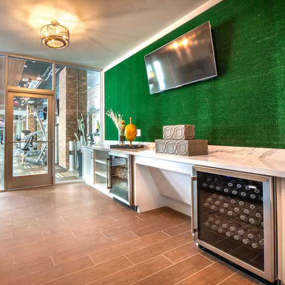 a kitchen with a green wall and a wine cooler.