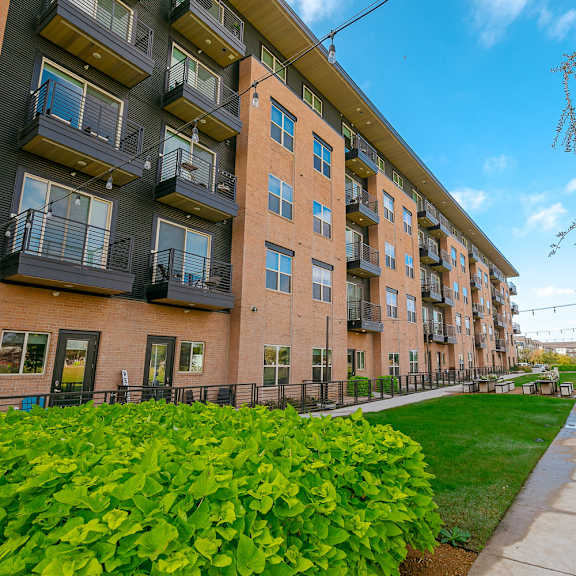 a long building with balconies and a walkway in front.