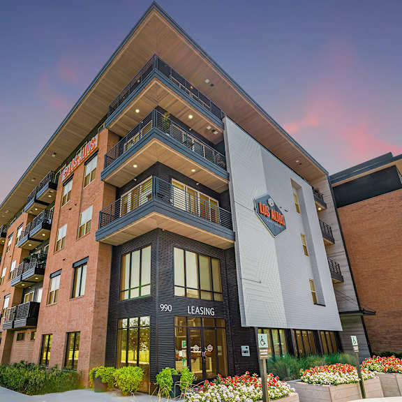a modern apartment building with a leasing sign on the front.