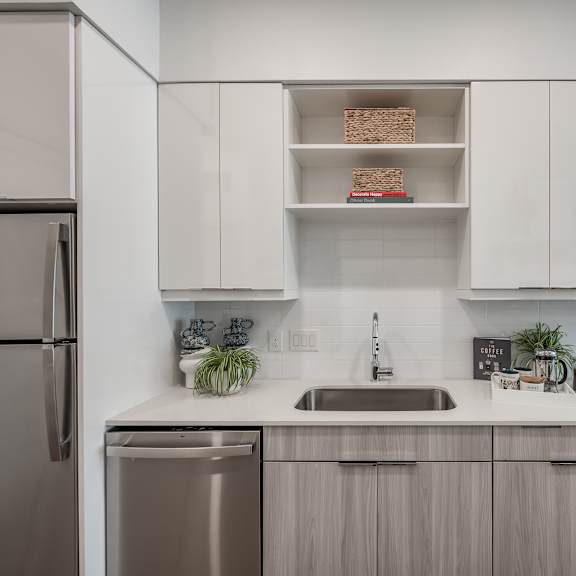 a kitchen with white countertops and stainless steel appliances
