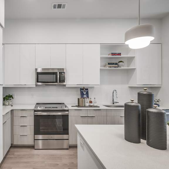 a kitchen with white cabinets and stainless steel appliances
