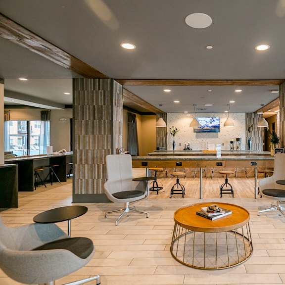 a modern living room with a bar area and comfortable seating.