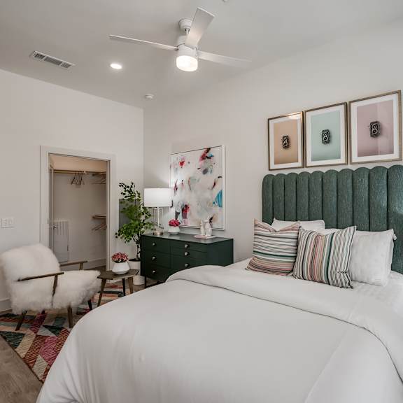 a bedroom with a large bed and a green headboard