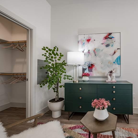 a bedroom with a green dresser and a white bed