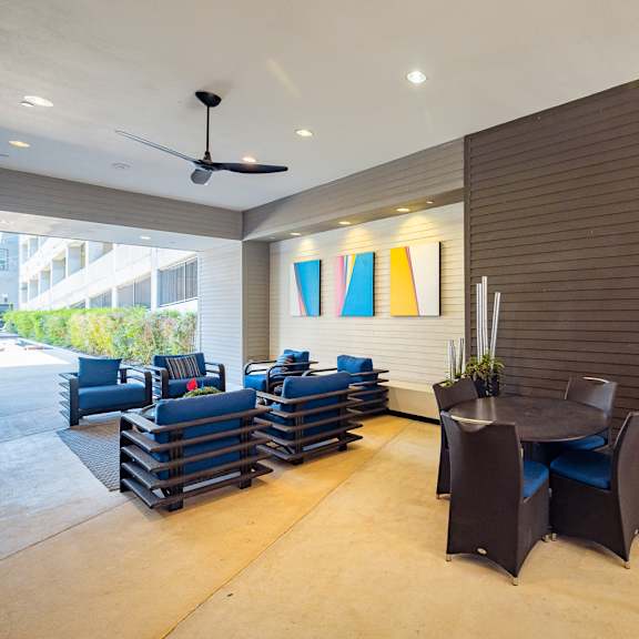 a room with a ceiling fan and a blue couch.