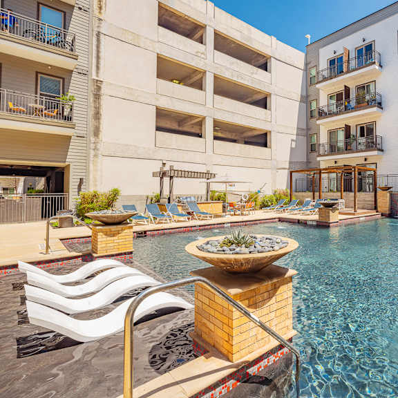 a large outdoor pool with a fountain in the middle of it.