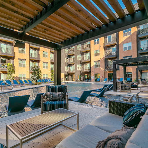 a patio with a pool and chairs.