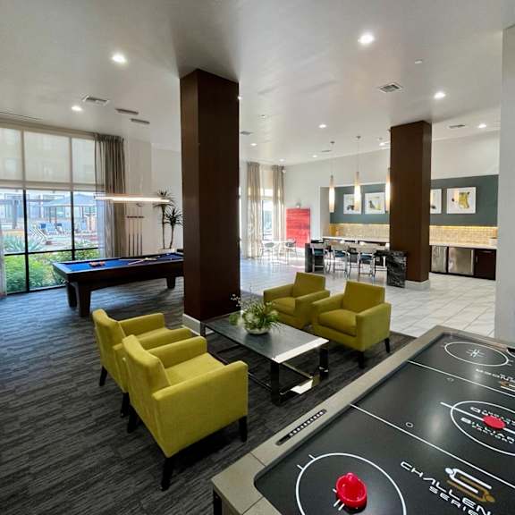 a modern room with a shiny black table in the middle and yellow chairs.