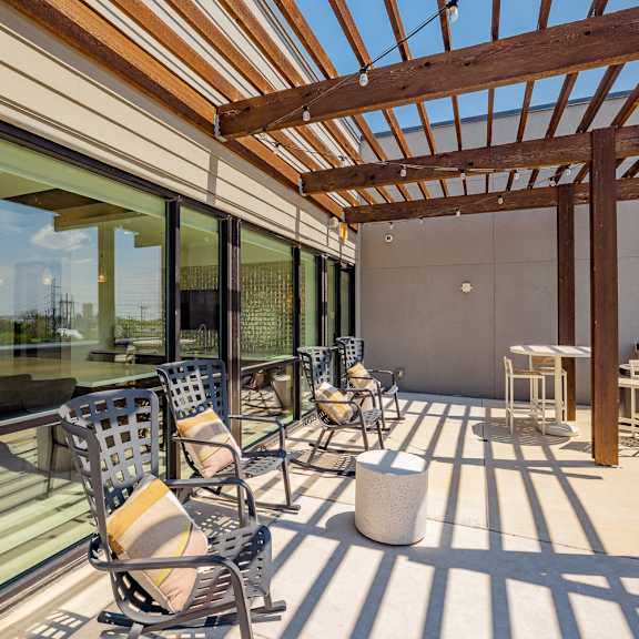 a sunroom with a wooden pergola and patio furniture.