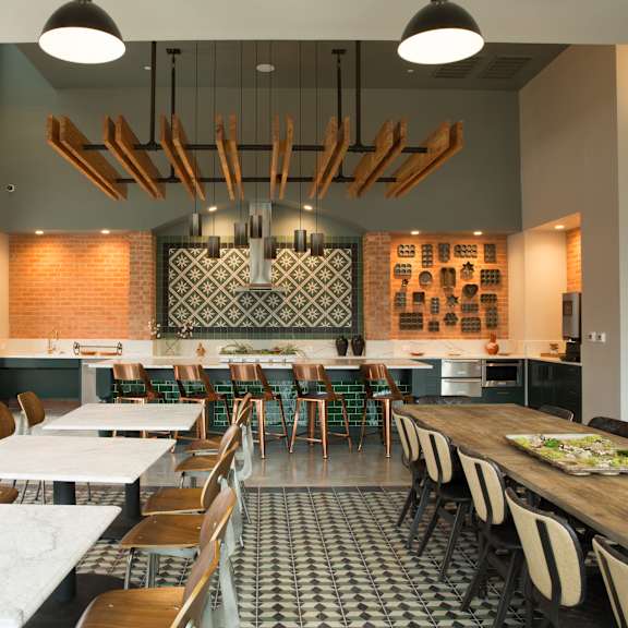 a restaurant with a long table and chairs in the middle of the room.