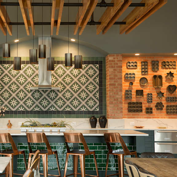 a kitchen with a white counter top and green tiles.