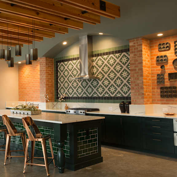 a kitchen with a brick wall and wooden ceiling.