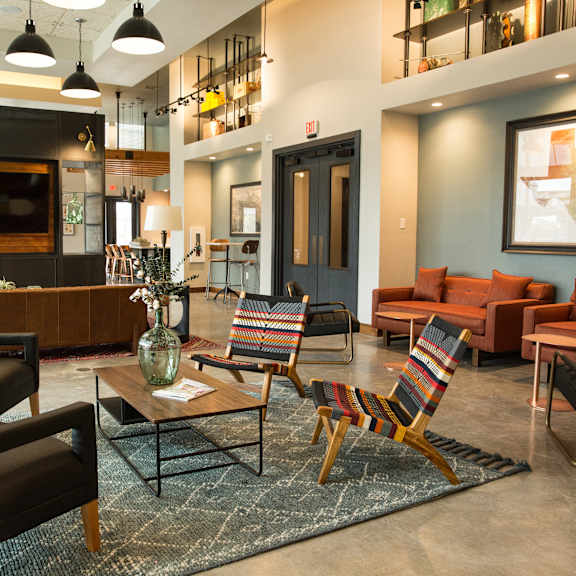 a living room with a black chair and a striped chair.
