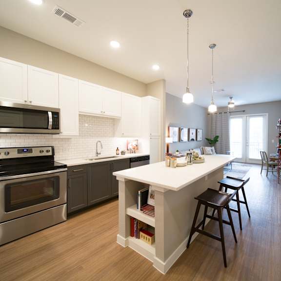 a modern kitchen with a large island and stainless steel appliances.