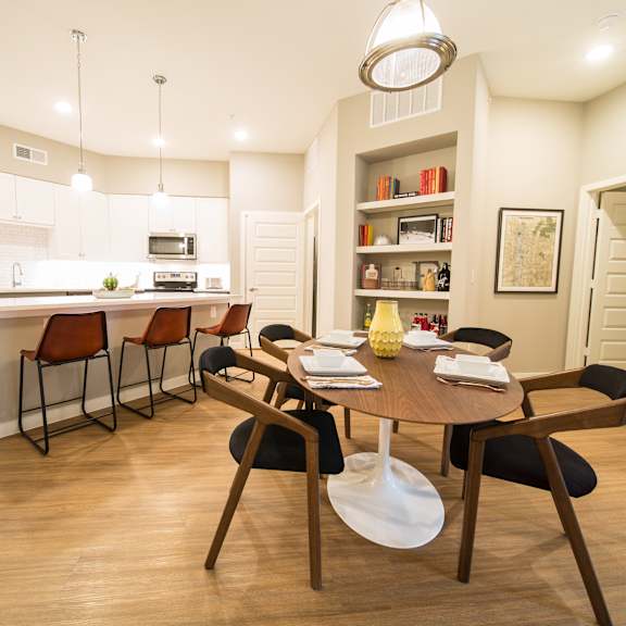 a modern kitchen with a dining table set for four.