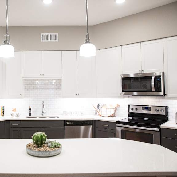 a kitchen with a refrigerator, oven, and microwave.