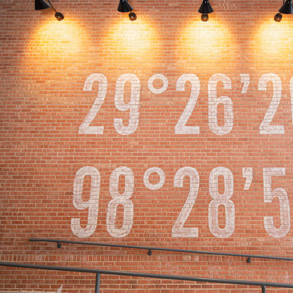 a brick wall with coordinates written on it.