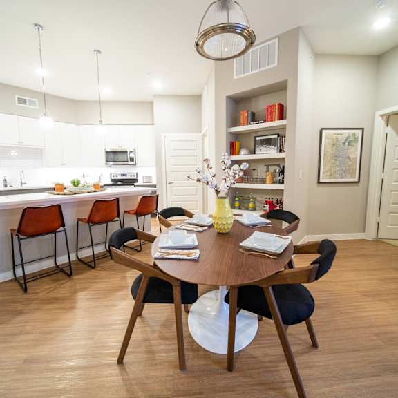 a modern kitchen with a dining table set for four.