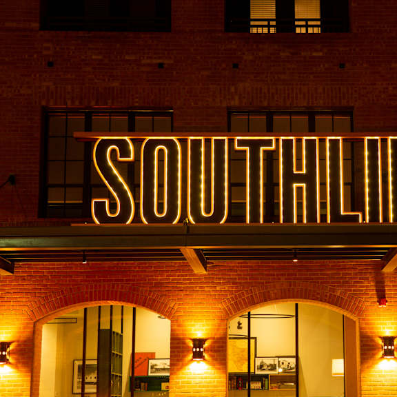 a building with a neon sign that says "southline".