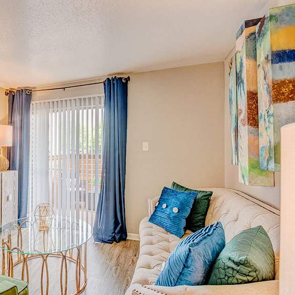 a living room with a white couch and a painting on the wall.