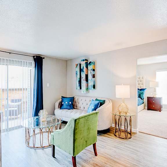 a living room with a green chair and a white couch.