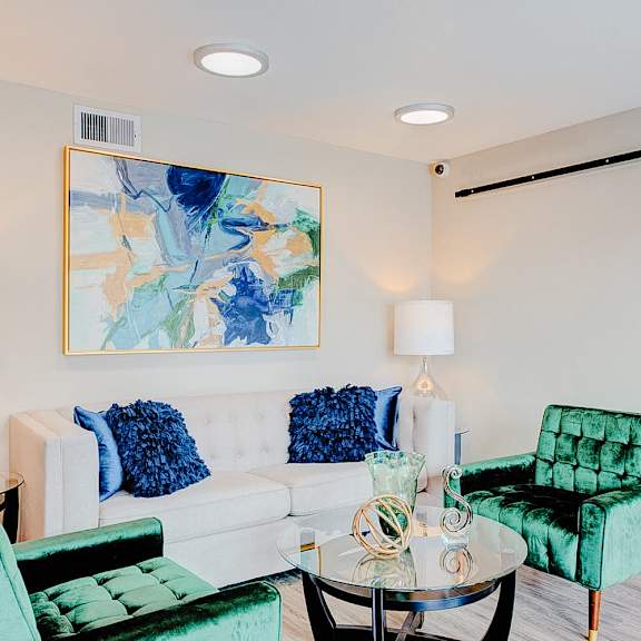 a living room with a green chair and a white couch.