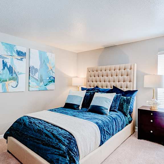 a bedroom with a large bed and two paintings on the wall.