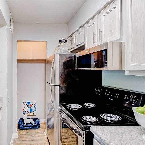 a kitchen with a black stove top oven and white cabinets.