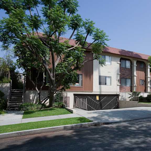 a row of houses with trees in front.