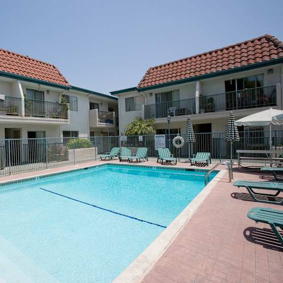 a swimming pool in front of apartment buildings.
