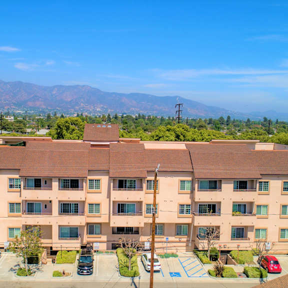 a large apartment complex with a parking lot in front.