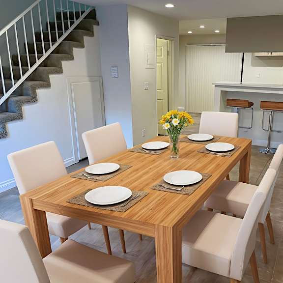 a dining table with chairs and a vase of flowers on top.
