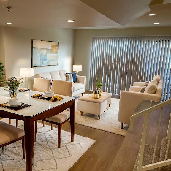 a dining room with a table set for six and a painting on the wall.