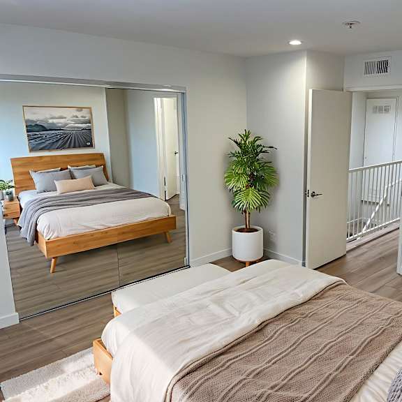 a bedroom with a large bed and a plant in a white pot.