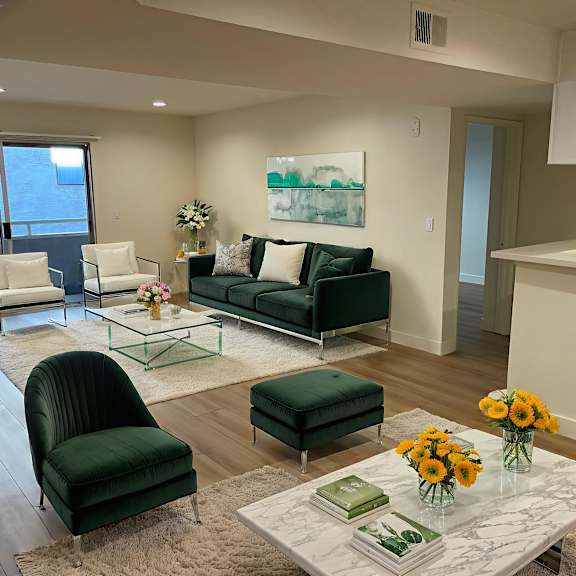 a living room with a green couch, two chairs, and a coffee table.